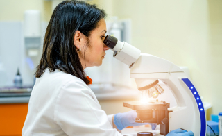A medical expert examining using a microscope.
