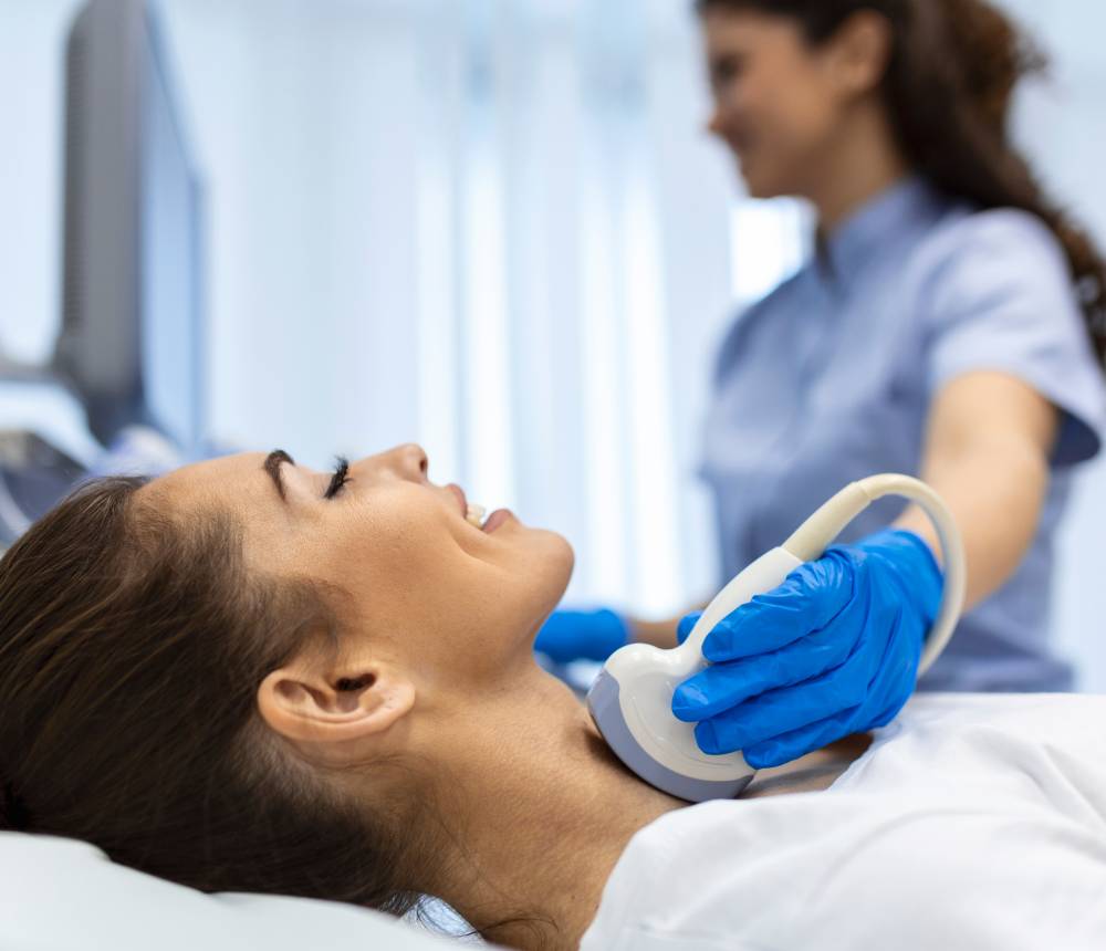 A female patient undergoing an ultrasound diagnostics of the endocrine system.
